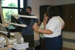 Bruce Ryan (far left), Tracey Hood (center), and Marla Glover (right) ponder the placement of the paddles on the base.