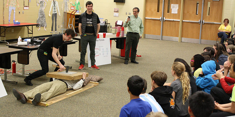 Students watching someone endure the dreaded Bed of Nails