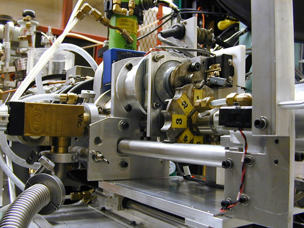 Purdue custom 8-sample changer pushed up against the gate valve showing the Geneva drive mechanism.