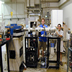 Tom Kiesel and Xiangshun Lu show off the ion source test facility, which they assembed from components given to us by Roy Middleton, University of Pennsylvania.