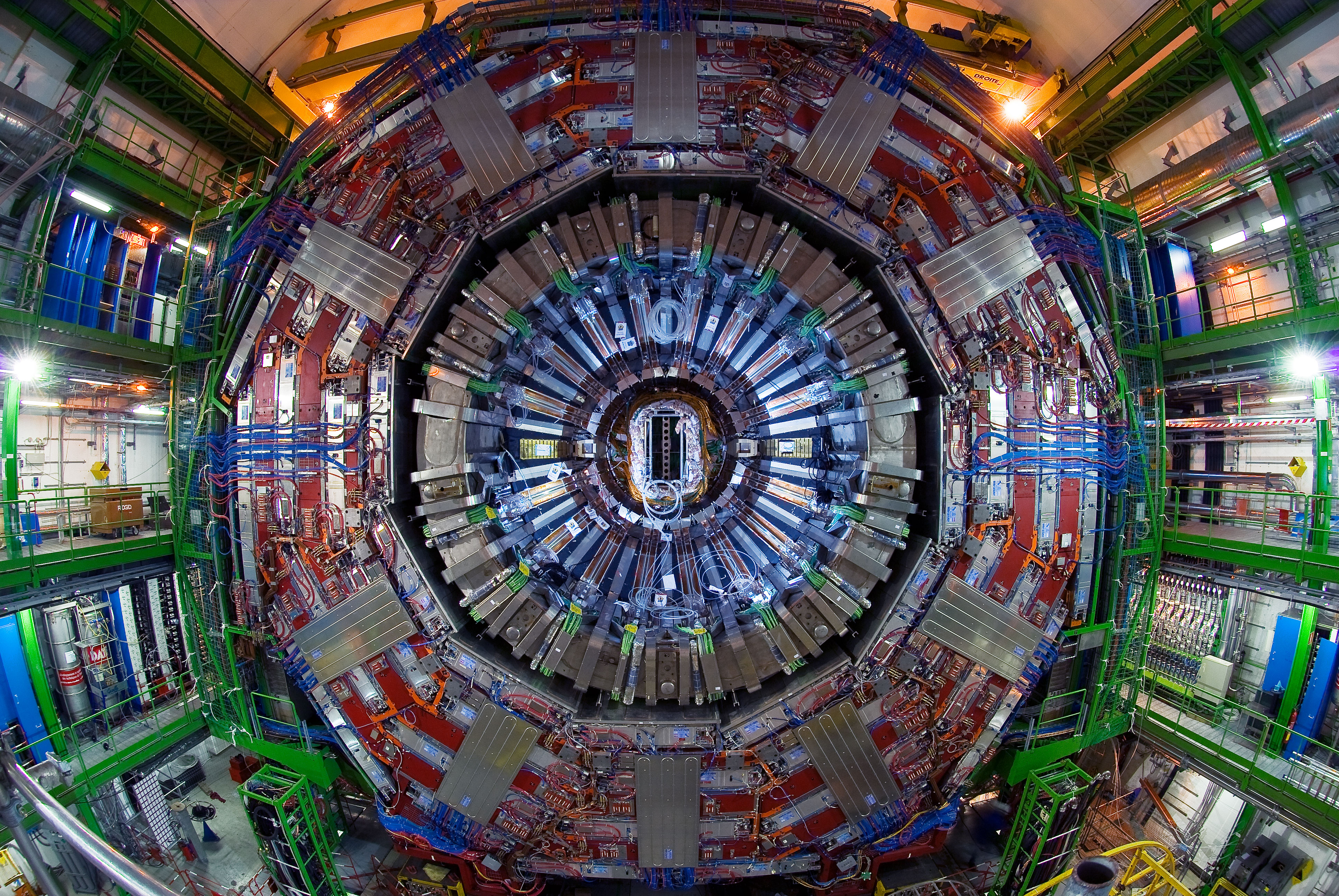 Jung HEP group member peering through a component of instrumentation