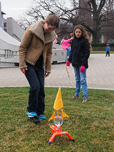 Female student demonstrating rocket