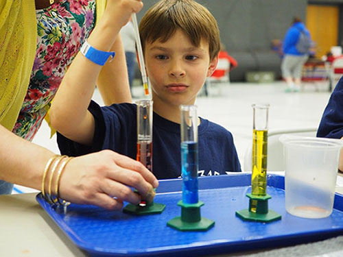 Male student at the Density Straws station